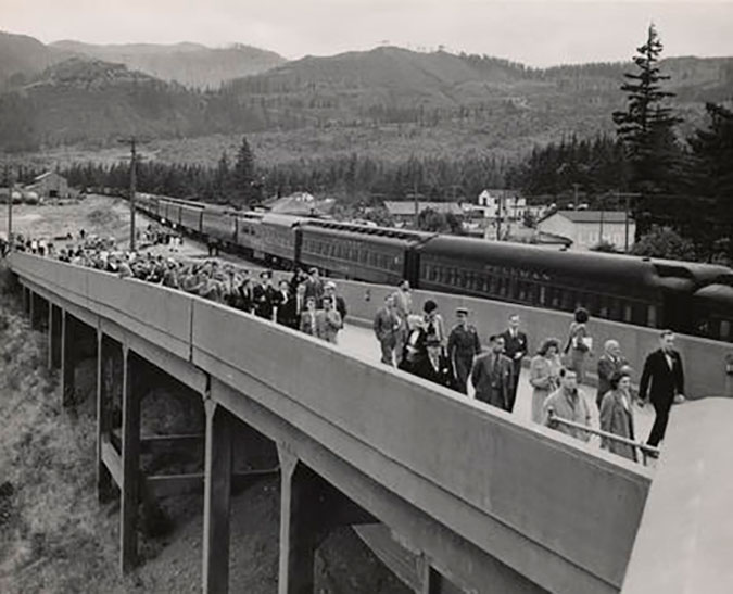  A crowd of people walking up a ramp next to an SP&S train at North Bonneville Station on June 29, 1945